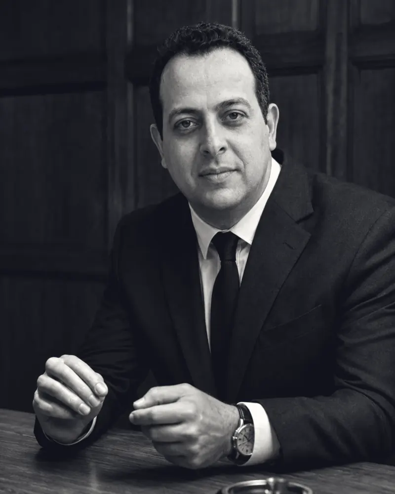 Black and white portrait of Mohamed B. Kumiha in a suit